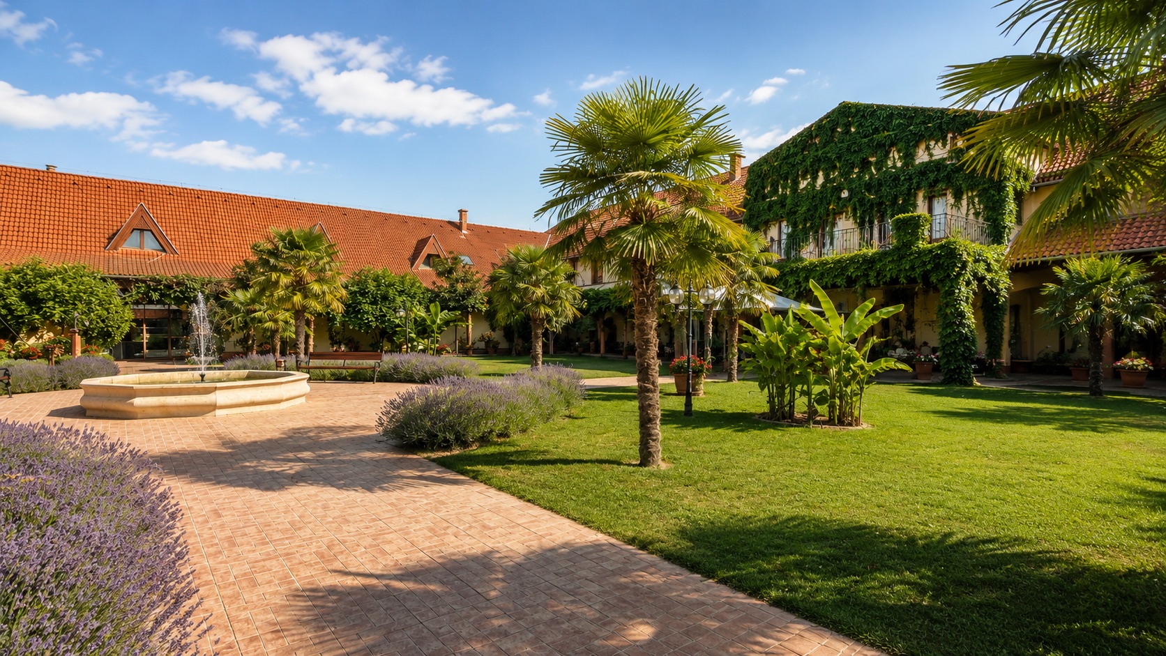 Család sétál a Vinum Wellness Hotel mediterrán kertjében Kiskőrösön nyári napsütésben